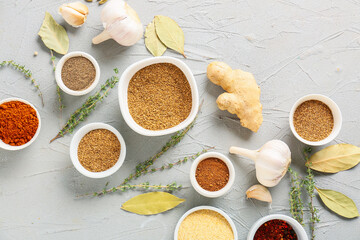 Bowls with different spices on light background