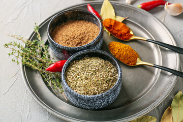 Bowls and spoons with different spices on light background, closeup