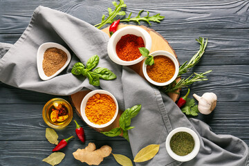 Bowls with different spices on dark wooden background