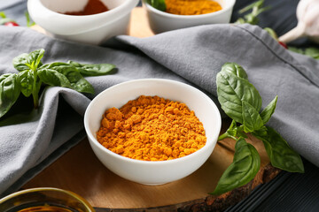 Bowl with turmeric powder on table, closeup