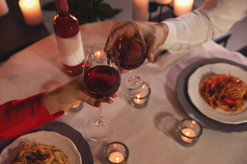 Couple clinking glasses of wine, above view. Romantic dinner