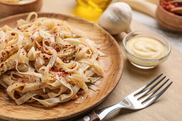 Plate with tasty noodles and chicken on wooden board, closeup
