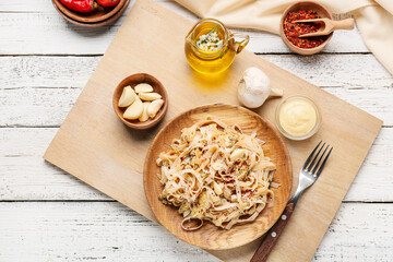 Plate with tasty noodles and chicken on light wooden background