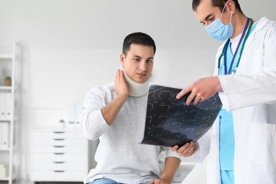 Young man with neck injury visiting doctor in clinic