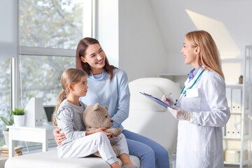 Woman with her little daughter visiting pediatrician in clinic