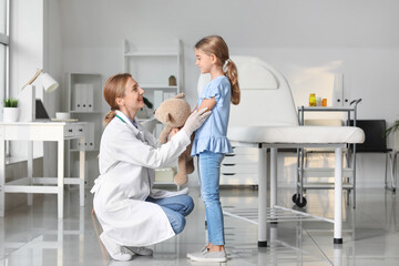 Pediatrician examining little girl in clinic