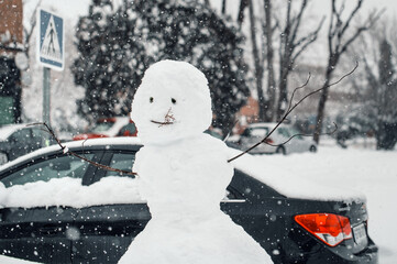 Snowman in city street in winter