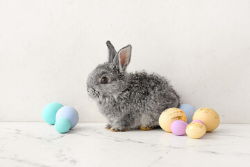 Cute rabbit and Easter eggs on light background