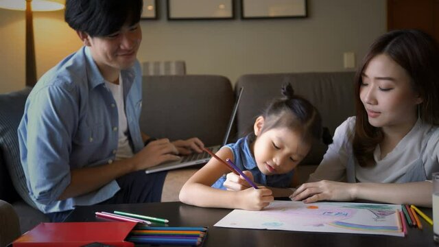 Asian parent teaching their daughter doing homework while work from home during coronavirus or covid-19 outbreak. Asian family, social distancing or homeschooling concept