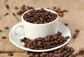 variety of roasted arabica and robusta coffee beans from Indonesia, pouring from a cup