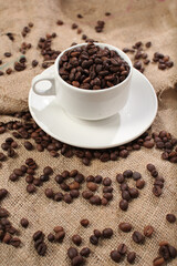 variety of roasted arabica and robusta coffee beans from Indonesia, pouring from a cup