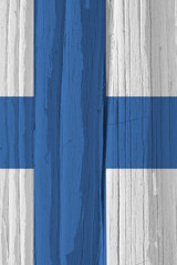 The flag of Finland on a dry wooden surface, cracked with age. Vertical background, wallpaper or...
