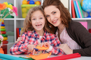 Cute little girl and her mother playing