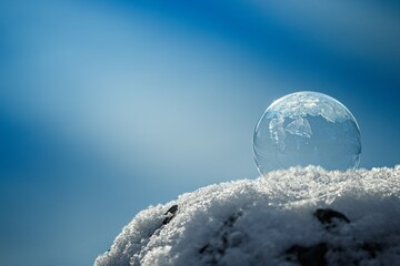 Gefrorene Seifenblase mit Schnee und blauen bokeh