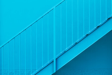 Escalera de hierro azul y pared azul. Vista de frente y de cerca. Copy space