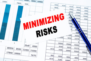 Text MINIMISING RISK on financial tables, the working paper . Business and financial conzept.