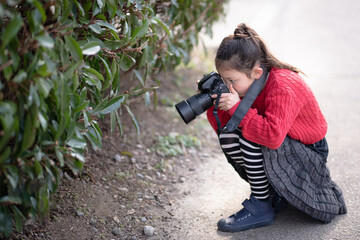 一眼レフカメラで写真を撮影する少女