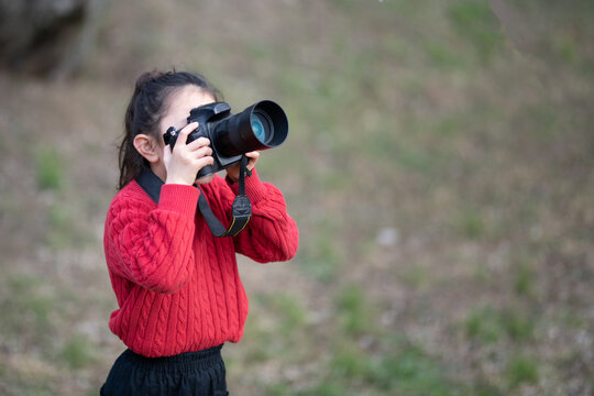 一眼レフカメラで写真を撮影する少女