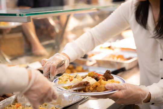 Woman Wearing Plastic Gloves Putting Food On A Plate - Celebration And Meal Concept