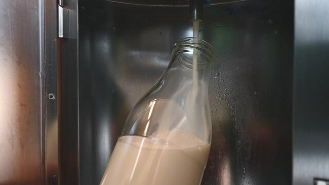 Abfüllen der Frischen Milch in einer Glasflasche an einer Milchtankstelle