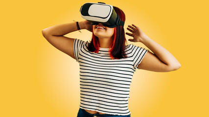 latin girl with virtual reality glasses on yellow background