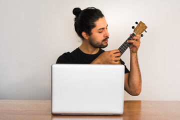 man learning online how to playing ukulele