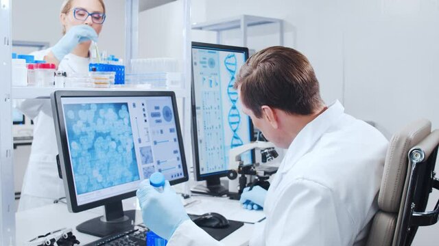 Professional team of scientists is working on a vaccine in a modern scientific research laboratory. Genetic engineer workplace. Future technology and science.