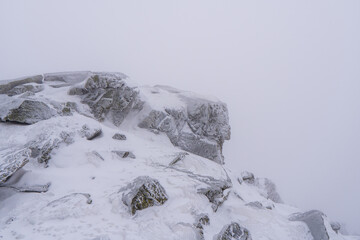 Gorgeous winter landscape in the mountains at snowy visibility with fog in the background, Czech Jeseniky Mountain