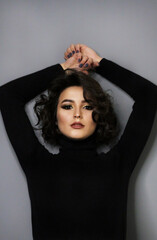 Beautiful young brunette model with bright make-up and curly hair