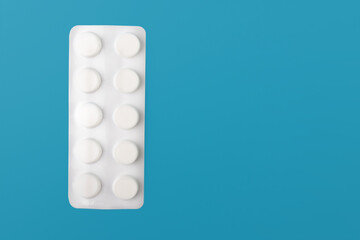 Medical capsules, pills on a blue background. Copy space