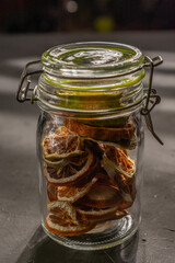 close up glass jars with homemade dehydrated lemon on black bottom