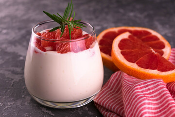 
A glass of yogurt with fresh grapefruit on a gray background.
Close-up.