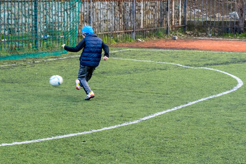 8 year old boy scores a goal while playing football