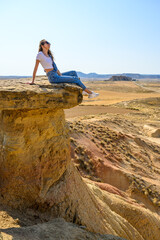 Woman in desert with landscape and old house built of earth