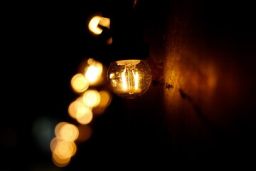 Fototapeta na wymiar glowing bulb and bokeh lighte in the dark