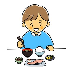 和食の朝ごはんをうれしそうに食べる男の子