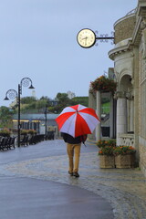 Man holding umbrella intown of Lyme Regis, Dorset.