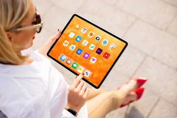 Woman using tablet with colorful home screen full of sample app icons
