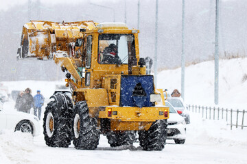 Snowy weather in winter city, defocused view to snow plow machine on the street