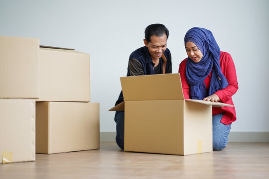 Portrait Of Young Muslim Couple Unloading Boxes For Moving To New House