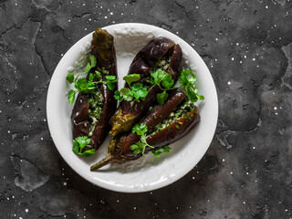 Korean style marinated stuffed cilantro, dill, garlic eggplant on a dark background, top view