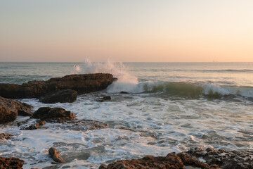 Sunset on the Atlantic ocean and waves breaking on the rocks