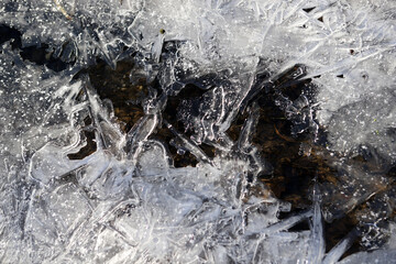 Eiskristalle wachsen von den Ufern über einen kleinen Bach