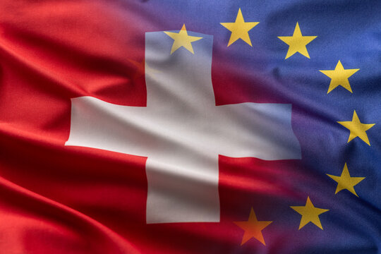 Flags of Switzerland and EU blowing in the wind