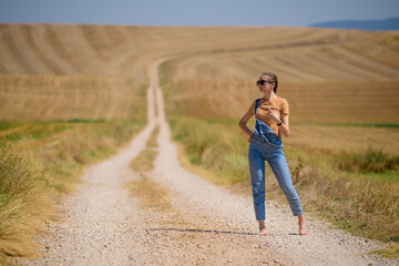 girl on the road with wheat field