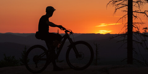Fototapeta na wymiar Silhouette of a cyclist admiring the sunset. 