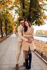 Fototapeta premium Romantic moments. Happy beautiful couple in love walking in autumn park.