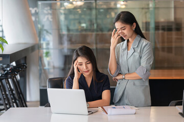 Portraits of two businesswomen consulting on their project while working in office room.