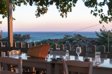 Chairs with tables, empty glass wine. Plants with hanging fruits in foreground, warm colors of golden hour, selective focus