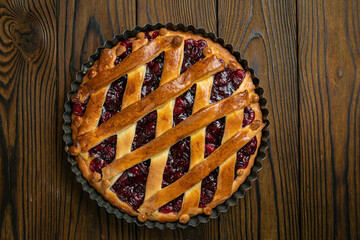 Cherry pie on a brown wooden table
